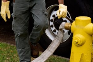 Worker is setting up a drain clean out of the fire hydrant.